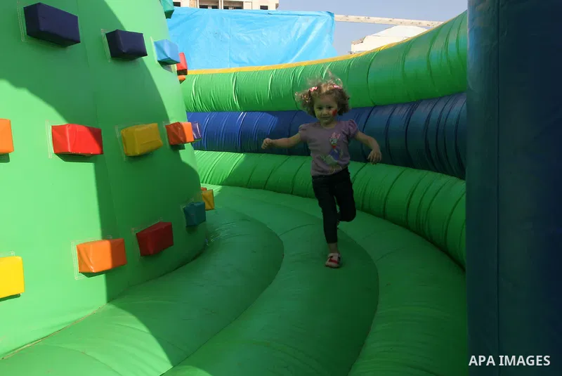 A Palestinian girl plays on a huge inflatable toy at Aqua Park, in Gaza City May 22, 2014. Photo by Mohammed Asad