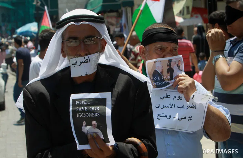 Palestinians take part a protest to solidarity with Palestinian prisoners held in Israeli jails, in the West Bank city of Tulkarem on May 24, 2014. Some 120 Palestinians jailed without trial in Israel have been on an ope...