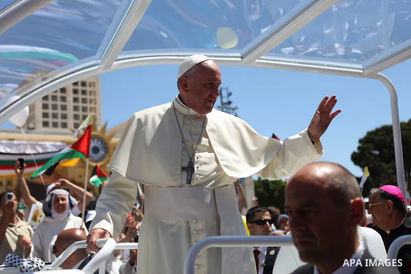 Pope Francis waves to the crowd as he arrives to give Mass at Manger Square, outside the Church of Nativity in the West Bank town of Bethlehem, May 25, 2014. Pope Francis on Sunday invited the Israeli and Palestinian pre...