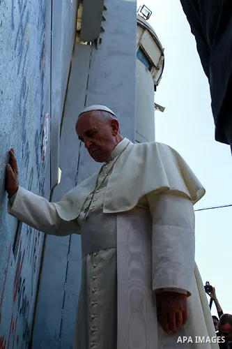 A handout picture provided by the Palestinian Presidential Guards shows Pope Francis touching the wall that separates Israel from the West Bank on his way to celebrate a mass in the Manger Square, in the West Bank city o...
