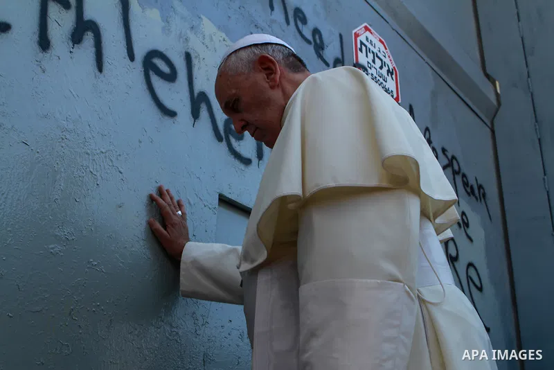 A handout picture provided by the Palestinian Presidential Guards shows Pope Francis touching the wall that separates Israel from the West Bank on his way to celebrate a mass in the Manger Square, in the West Bank city o...