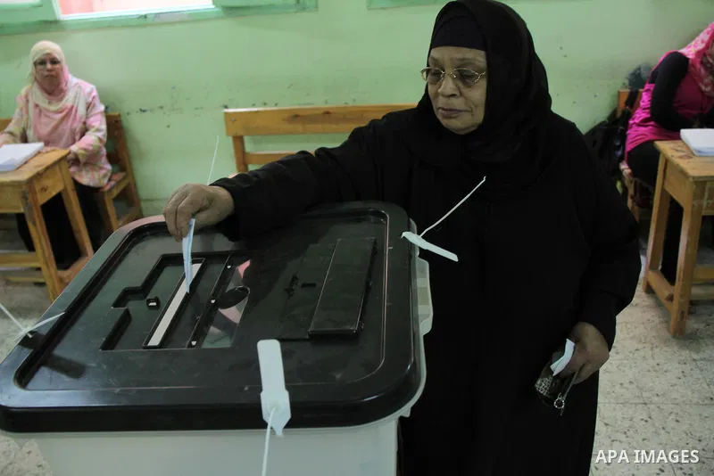 A Egyptian woman casts her vote at a polling station in Cairo on May 26, 2014. Egyptians begin voting in a new presidential election which ex-army chief Abdel Fattah al-Sisi, who ousted the elected Islamist leader, is ex...