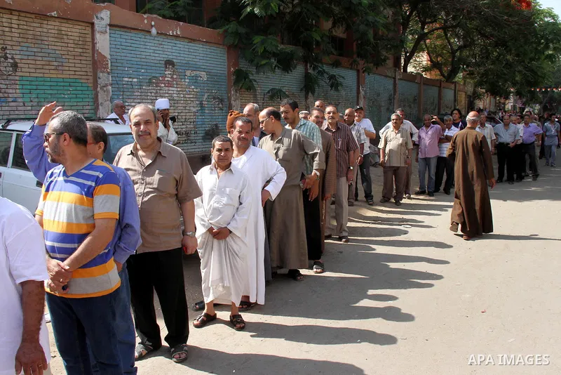 Egyptians queue outside a polling station in Cairo on May 26, 2014. Egyptians begin voting in a new presidential election which ex-army chief Abdel Fattah al-Sisi, who ousted the elected Islamist leader, is expected to e...