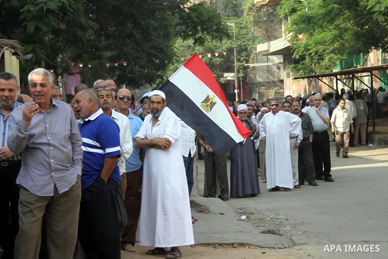 Egyptians queue outside a polling station in Cairo on May 26, 2014. Egyptians begin voting in a new presidential election which ex-army chief Abdel Fattah al-Sisi, who ousted the elected Islamist leader, is expected to e...