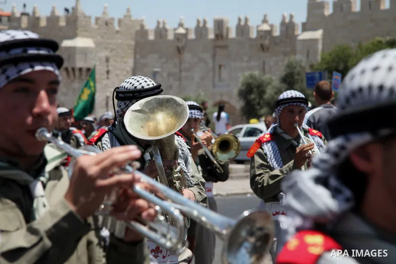 Palestinian scouts play musical instruments as they parade through the streets during a ceremony commemorating the Islamic holiday of Isra Mi'raj, at the Al-Aqsa mosque compound in the Old City of Jerusalem on May 26, 20...