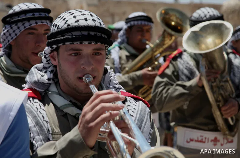 Palestinian scouts play musical instruments as they parade through the streets during a ceremony commemorating the Islamic holiday of Isra Mi'raj, at the Al-Aqsa mosque compound in the Old City of Jerusalem on May 26, 20...