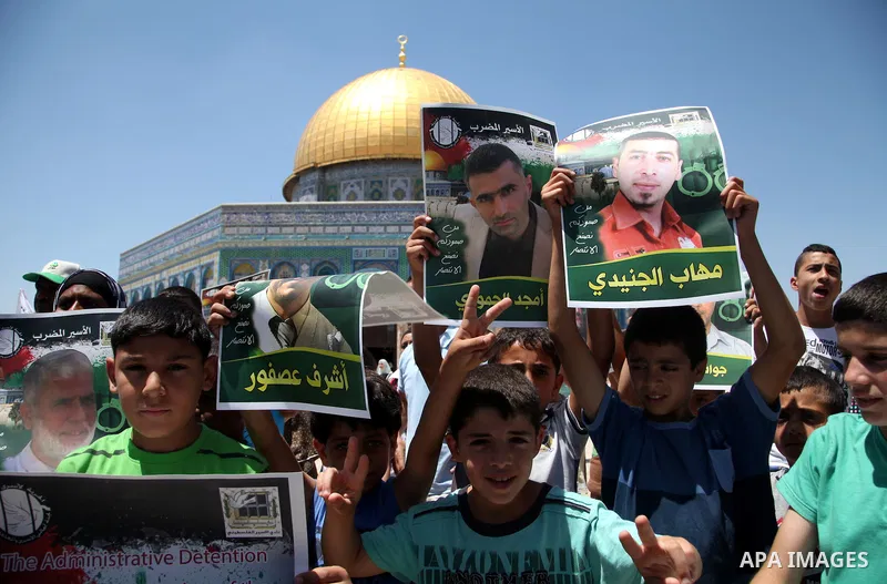 Palestinian children hold pictures of prisoners during a rally to show solidarity with Palestinian prisoners held in Israeli jails, in front of the Dome of the Rock at the Al-Aqsa mosque compound in the Old City of Jerus...