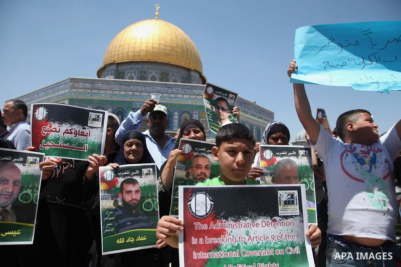 Palestinian children hold pictures of prisoners during a rally to show solidarity with Palestinian prisoners held in Israeli jails, in front of the Dome of the Rock at the Al-Aqsa mosque compound in the Old City of Jerus...