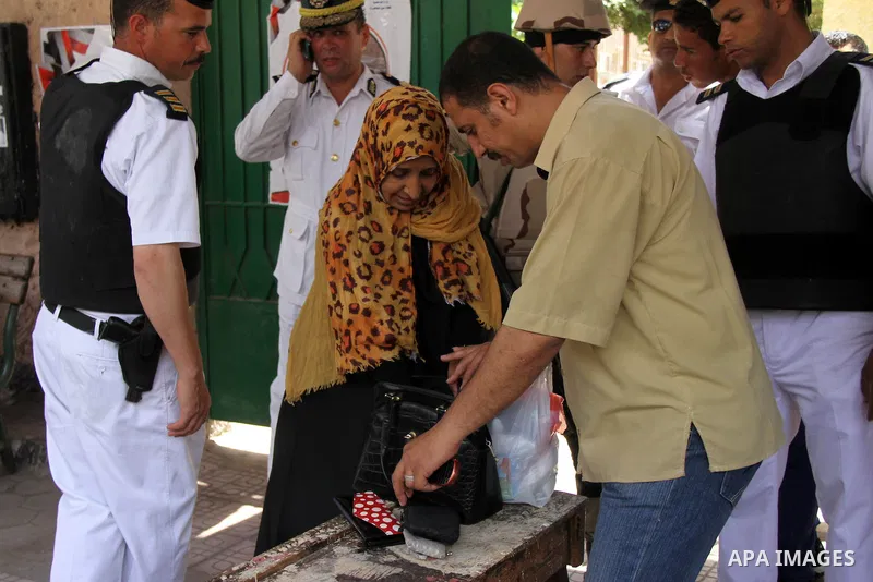 Egyptian soldiers inspect a bag woman before casting her vote at a polling station in Cairo, Egypt, 28 May 2014. Polling stations opened on 28 May for the final day of the voting after election commission's decision to e...