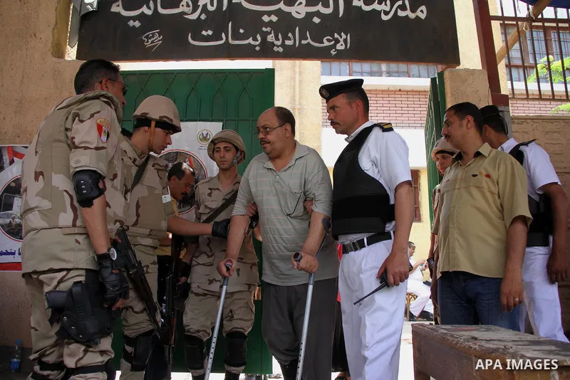 Egyptian soldiers help a man after voting during the presidential election at a polling station in Cairo, Egypt, 28 May 2014. Polling stations opened on 28 May for the final day of the voting after election commission's...