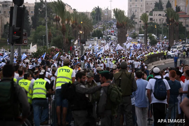 Ultra-nationalist Israelis wave their national flags during the "flag march" through Damascus Gate in east Jerusalem on May 28, 2014 as the country celebrates the anniversary of its capture in the 1967 Six-Day War. Feari...