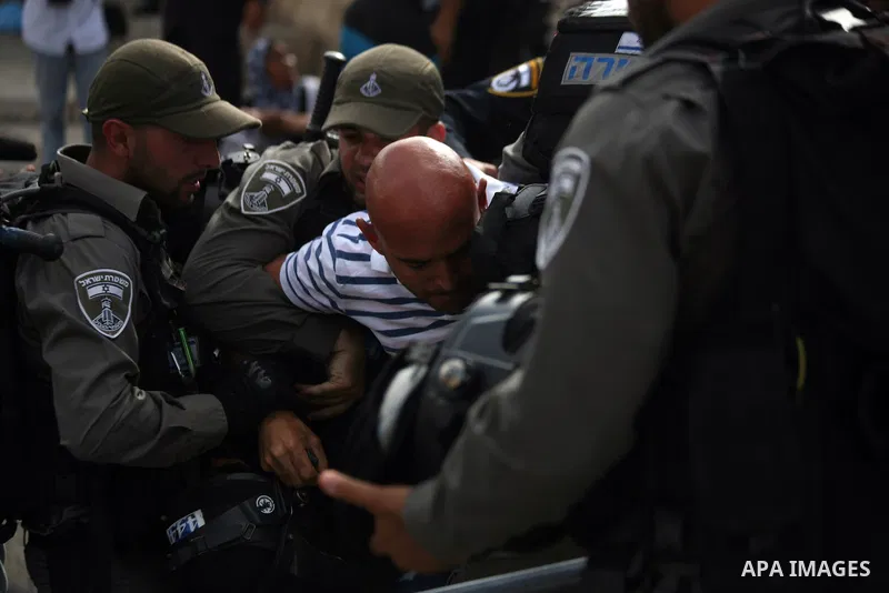 Israeli border guards detain a Palestinian man as Ultra-nationalist Israelis take part in the "flag march" through Damascus Gate in east Jerusalem on May 28, 2014 celebrating the anniversary of its capture in the 1967 Si...