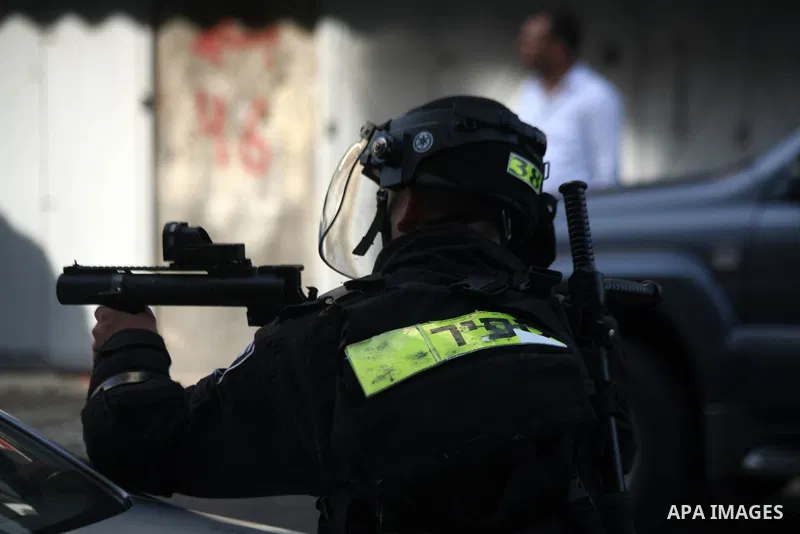 An Israeli border guard fires tear gas towards Palestinians as Ultra-nationalist Israelis take part in the "flag march" through Damascus Gate in east Jerusalem on May 28, 2014 celebrating the anniversary of its capture i...
