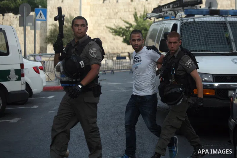Israeli border guards detain a Palestinian man as Ultra-nationalist Israelis take part in the "flag march" through Damascus Gate in east Jerusalem on May 28, 2014 celebrating the anniversary of its capture in the 1967 Si...