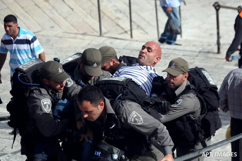 Israeli border guards detain a Palestinian man as Ultra-nationalist Israelis take part in the "flag march" through Damascus Gate in east Jerusalem on May 28, 2014 celebrating the anniversary of its capture in the 1967 Si...
