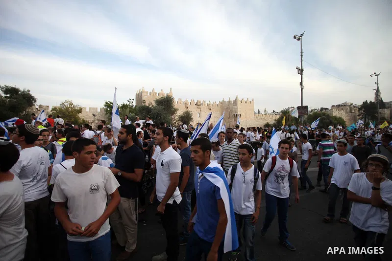 Ultra-nationalist Israelis wave their national flags during the "flag march" through Damascus Gate in east Jerusalem on May 28, 2014 as the country celebrates the anniversary of its capture in the 1967 Six-Day War. Feari...