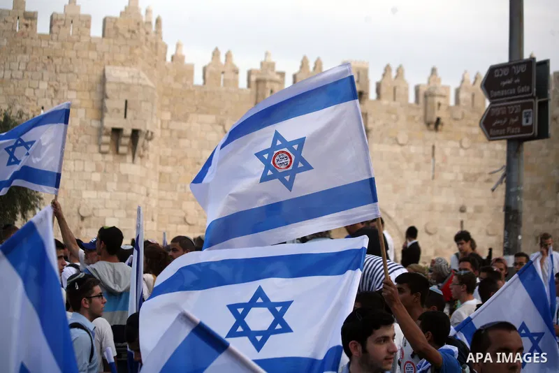 Ultra-nationalist Israelis wave their national flags during the "flag march" through Damascus Gate in east Jerusalem on May 28, 2014 as the country celebrates the anniversary of its capture in the 1967 Six-Day War. Feari...
