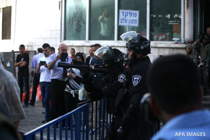 An Israeli border guard fires tear gas towards Palestinians as Ultra-nationalist Israelis take part in the "flag march" through Damascus Gate in east Jerusalem on May 28, 2014 celebrating the anniversary of its capture i...