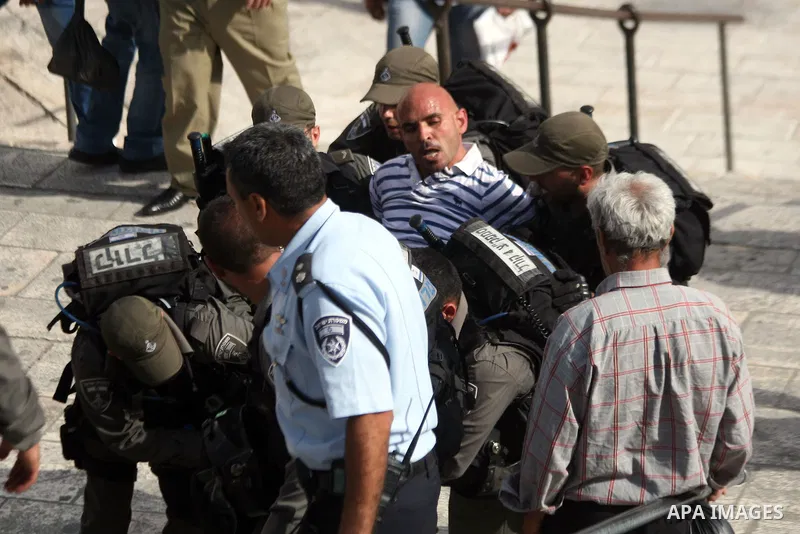 Israeli border guards detain a Palestinian man as Ultra-nationalist Israelis take part in the "flag march" through Damascus Gate in east Jerusalem on May 28, 2014 celebrating the anniversary of its capture in the 1967 Si...
