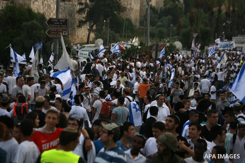 Ultra-nationalist Israelis wave their national flags during the "flag march" through Damascus Gate in east Jerusalem on May 28, 2014 as the country celebrates the anniversary of its capture in the 1967 Six-Day War. Feari...