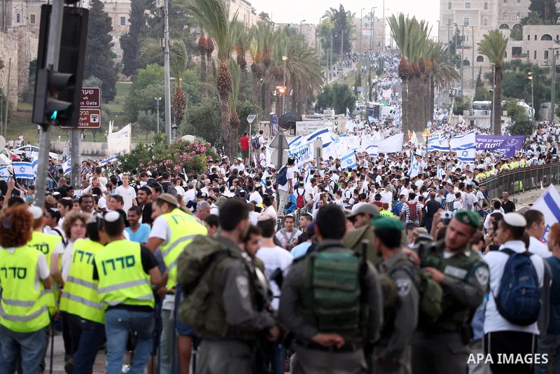 Ultra-nationalist Israelis wave their national flags during the "flag march" through Damascus Gate in east Jerusalem on May 28, 2014 as the country celebrates the anniversary of its capture in the 1967 Six-Day War. Feari...