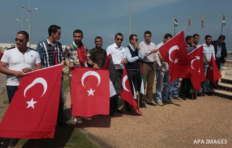 Palestinian men hold a Turkish flag during a rally ahead of the 4th anniversary of the Mavi Marmara Gaza flotilla incident, at the seaport of Gaza City May 29, 2014. Nine activists, eight Turkish and one Turkish-American...