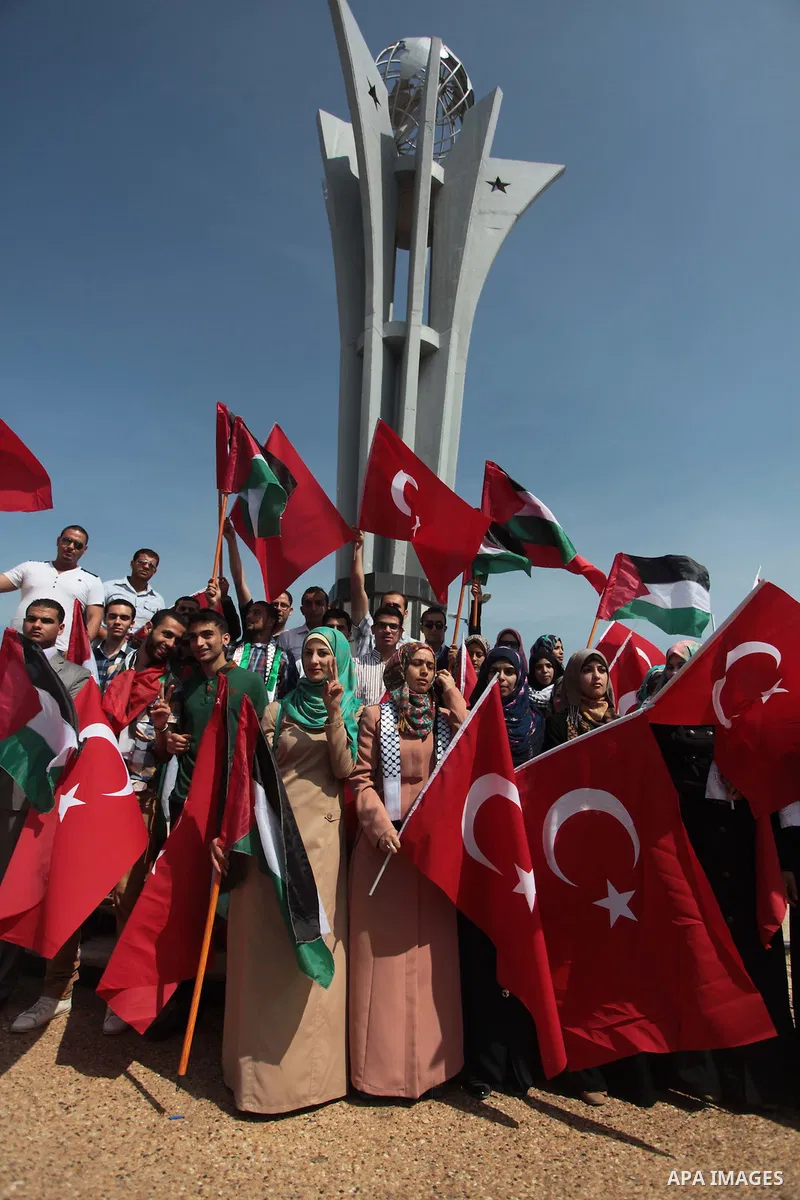 Palestinian women hold a Turkish flag during a rally ahead of the 4th anniversary of the Mavi Marmara Gaza flotilla incident, at the seaport of Gaza City May 29, 2014. Nine activists, eight Turkish and one Turkish-Americ...