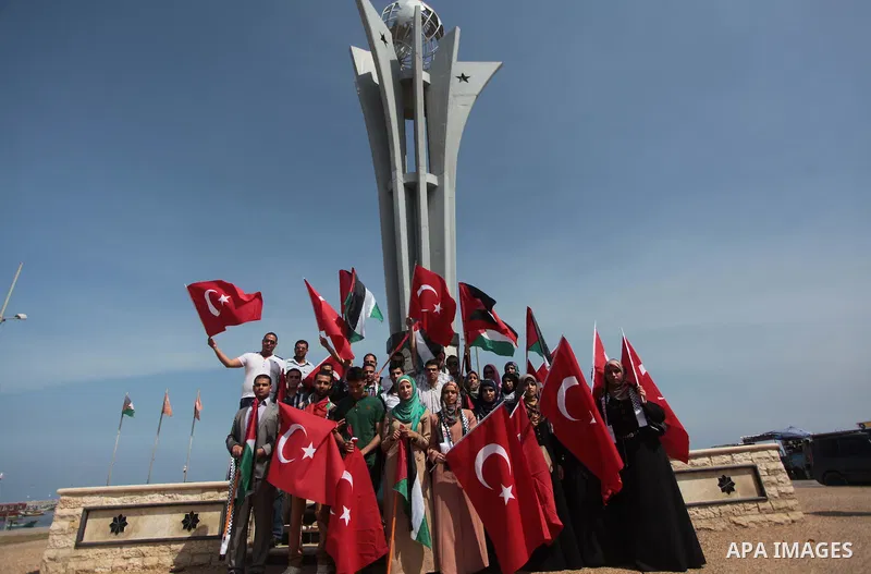 Palestinian women hold a Turkish flag during a rally ahead of the 4th anniversary of the Mavi Marmara Gaza flotilla incident, at the seaport of Gaza City May 29, 2014. Nine activists, eight Turkish and one Turkish-Americ...