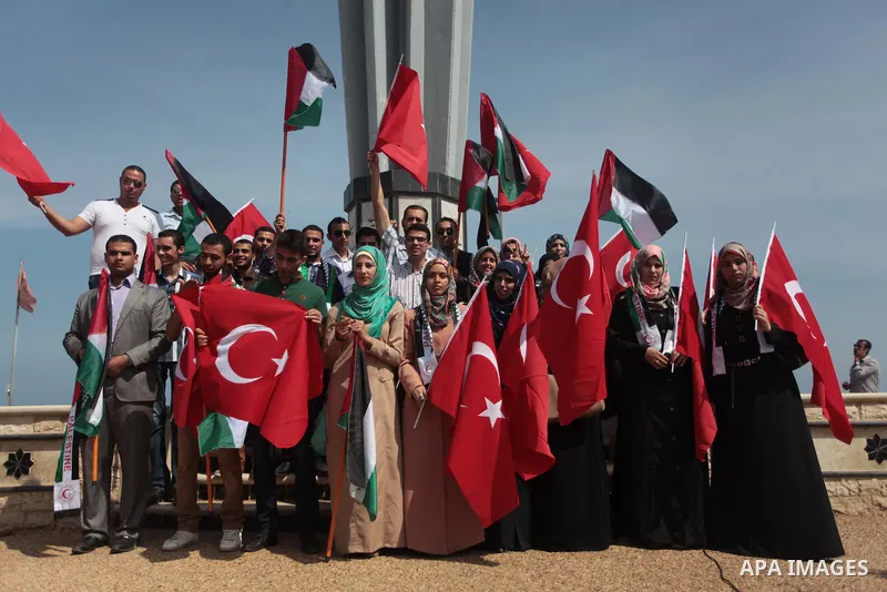 Palestinian women hold a Turkish flag during a rally ahead of the 4th anniversary of the Mavi Marmara Gaza flotilla incident, at the seaport of Gaza City May 29, 2014. Nine activists, eight Turkish and one Turkish-Americ...