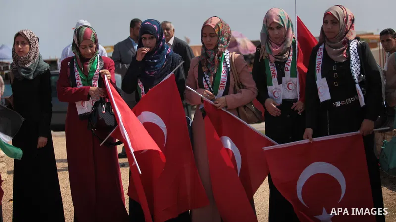 Palestinian women hold a Turkish flag during a rally ahead of the 4th anniversary of the Mavi Marmara Gaza flotilla incident, at the seaport of Gaza City May 29, 2014. Nine activists, eight Turkish and one Turkish-Americ...