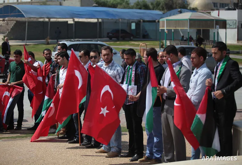 Palestinian men hold a Turkish flag during a rally ahead of the 4th anniversary of the Mavi Marmara Gaza flotilla incident, at the seaport of Gaza City May 29, 2014. Nine activists, eight Turkish and one Turkish-American...