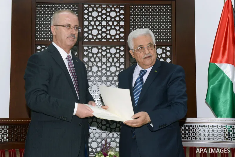 Palestinian Prime Minister Rami Hamdallah receives a designation letter from Palestinian President Mahmoud Abbas to head a unity government, in the West Bank city of Ramallah May 29, 2014. Rival Palestinian factions Fata...