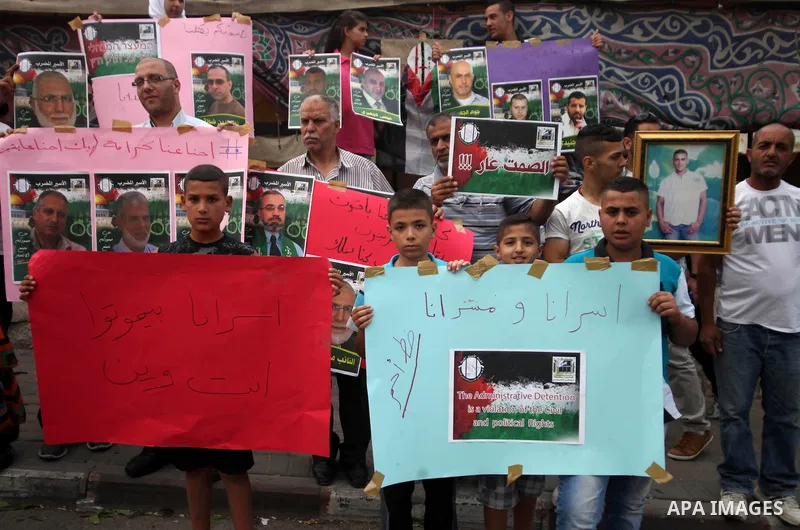 Palestinian youths hold banners during a protest to solidarity with Palestinian prisoners, in the East Jerusalem neighborhood of Silwan on May 29, 2014. It was about 120 Palestinians imprisoned without trial in Israel on...