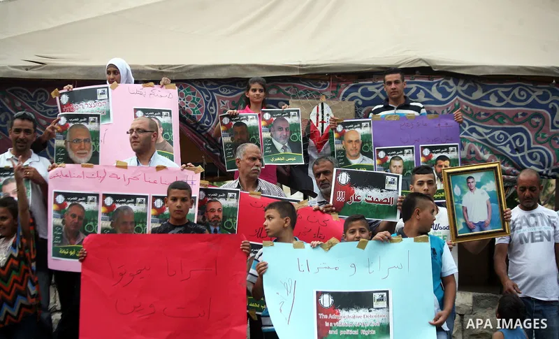 Palestinian youths hold banners during a protest to solidarity with Palestinian prisoners, in the East Jerusalem neighborhood of Silwan on May 29, 2014. It was about 120 Palestinians imprisoned without trial in Israel on...