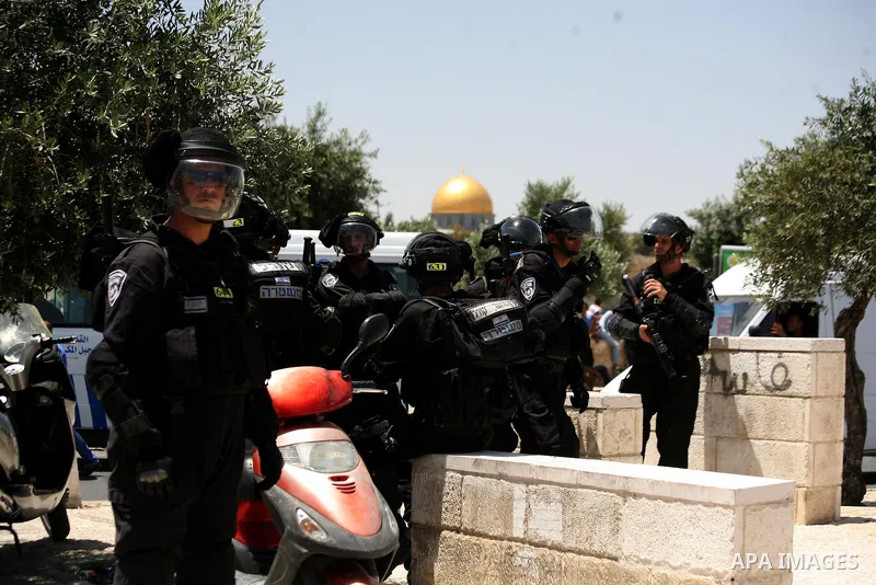 Israeli riot police stand guard as Palestinian muslim worshipers attend the Friday prayers in the East Jerusalem neighbourhood of Ras al-Amud after being refused entry into the Al-Aqsa compound in Jerusalem, 30 May 2014....