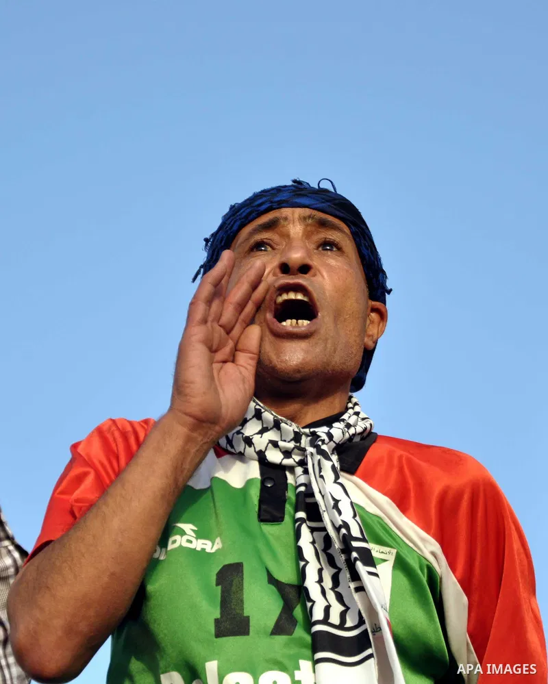 A Palestinian man shout slogans as he watches the match between their national team and the Philippine team during the final of the AFC Challenge Cup in Maldives, in Gaza City on May 30, 2014. Photo by Mohammed Talatene