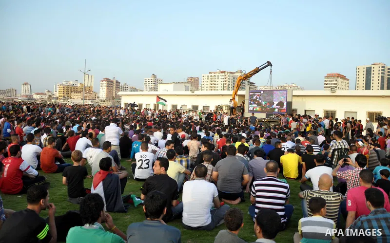 Palestinians watch the match between their national team and the Philippine team during the final of the AFC Challenge Cup in Maldives, in Gaza City on May 30, 2014. Photo by Mohammed Talatene