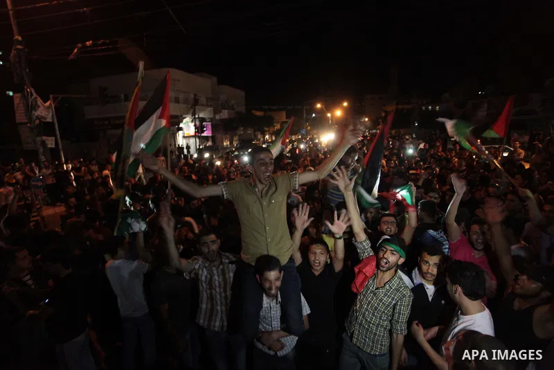 Palestinians celebrate in Gaza City on May 30, 2014, after Palestine qualified for their maiden Asian Cup appearance with a 1-0 win over injury-hit Philippines in the final of the AFC Challenge Cup in Maldives. Photo by...