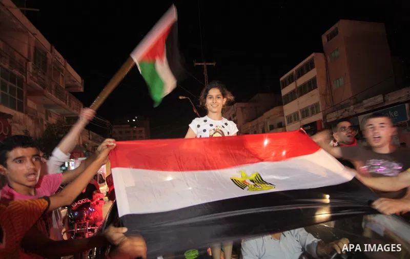 Palestinians celebrate in Gaza City on May 30, 2014, after Palestine qualified for their maiden Asian Cup appearance with a 1-0 win over injury-hit Philippines in the final of the AFC Challenge Cup in Maldives. Photo by...