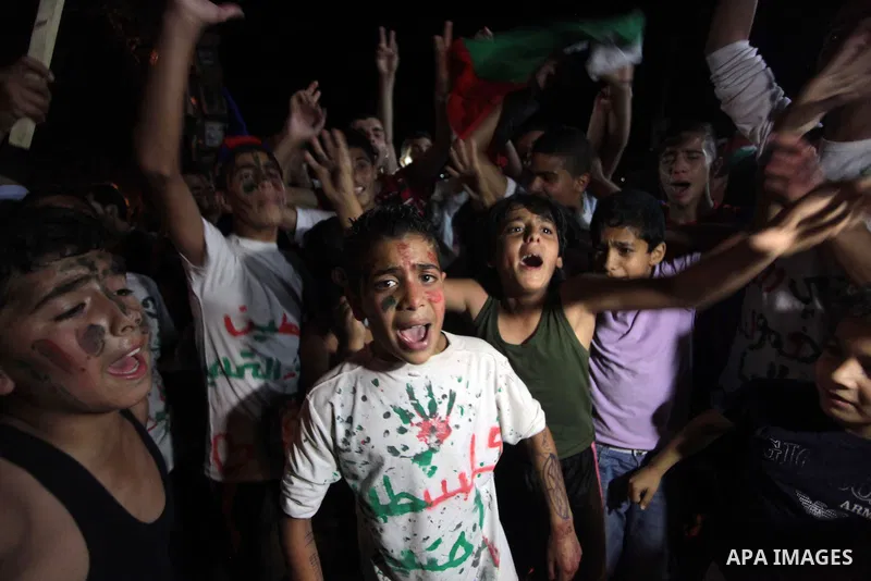 Palestinians celebrate in Gaza City on May 30, 2014, after Palestine qualified for their maiden Asian Cup appearance with a 1-0 win over injury-hit Philippines in the final of the AFC Challenge Cup in Maldives. Photo by...