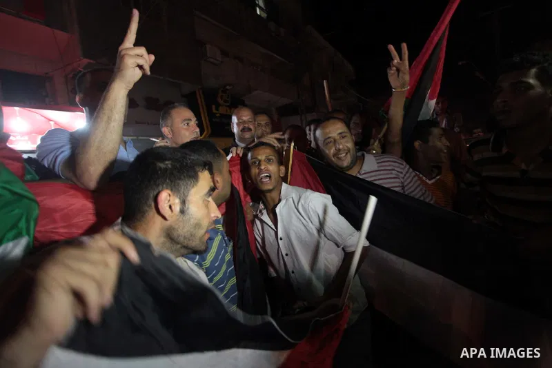Palestinians celebrate in Gaza City on May 30, 2014, after Palestine qualified for their maiden Asian Cup appearance with a 1-0 win over injury-hit Philippines in the final of the AFC Challenge Cup in Maldives. Photo by...