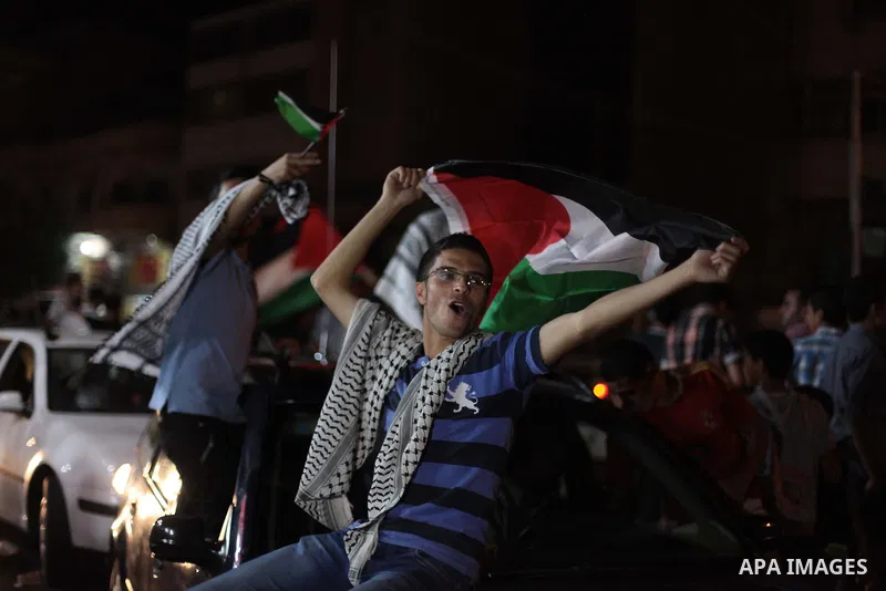Palestinians celebrate in Gaza City on May 30, 2014, after Palestine qualified for their maiden Asian Cup appearance with a 1-0 win over injury-hit Philippines in the final of the AFC Challenge Cup in Maldives. Photo by...