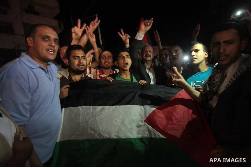 Palestinians celebrate in Gaza City on May 30, 2014, after Palestine qualified for their maiden Asian Cup appearance with a 1-0 win over injury-hit Philippines in the final of the AFC Challenge Cup in Maldives. Photo by...