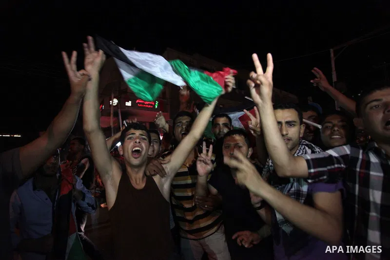 Palestinians celebrate in Gaza City on May 30, 2014, after Palestine qualified for their maiden Asian Cup appearance with a 1-0 win over injury-hit Philippines in the final of the AFC Challenge Cup in Maldives. Photo by...