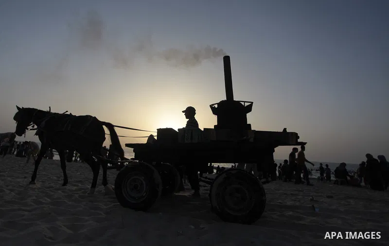 A Palestinian man sells grilled Potatoes on a beach, in Gaza City, on May 30, 2014. Gaza residents ran to the beach to cool off during the hot weather, as high temperatures hit the city Photo by Ashraf Amra