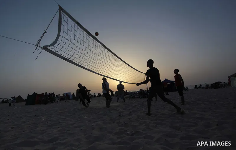 Palestinian youths play football during a sunset, in Gaza City, on May 30, 2014. Gaza residents ran to the beach to cool off during the hot weather, as high temperatures hit the city Photo by Ashraf Amra