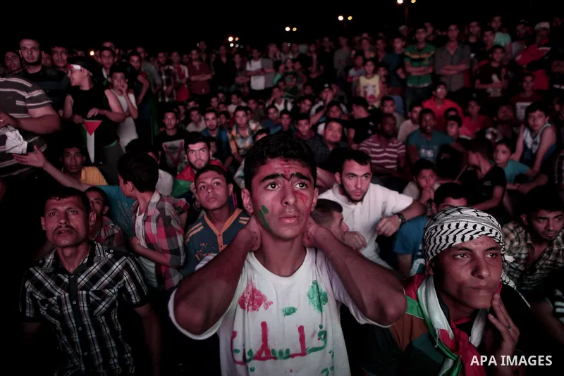 Palestinians cheer as they watch the soccer match between their national team and Philippines on large screens during the AFC Cup Final, in Gaza City May 30, 2014. Photo by Ezz Zanoun