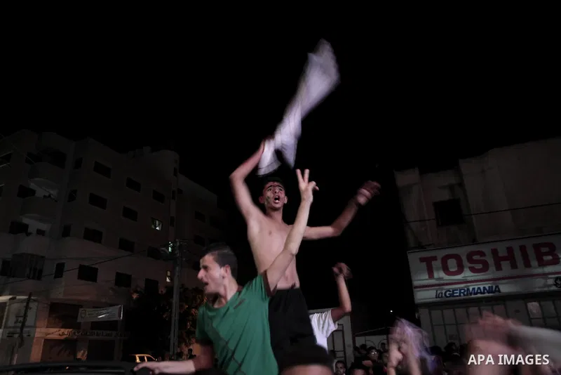Palestinians celebrate in Gaza City on May 30, 2014, after Palestine qualified for their maiden Asian Cup appearance with a 1-0 win over injury-hit Philippines in the final of the AFC Challenge Cup in Maldives. Photo by...
