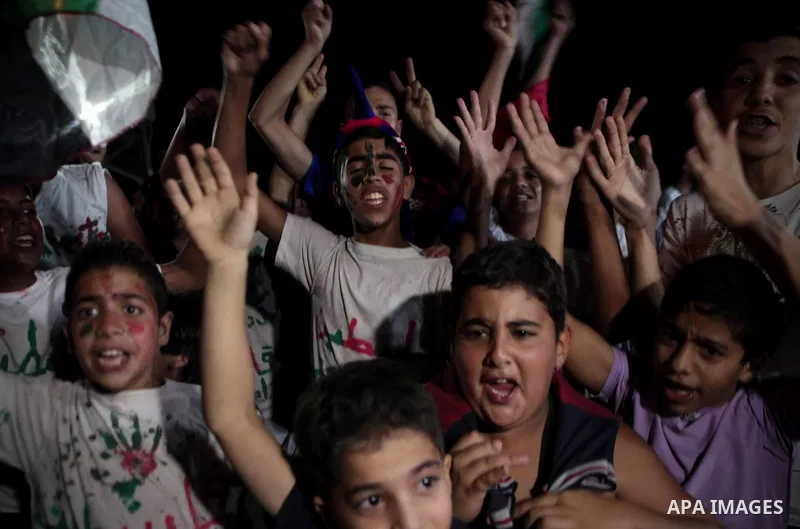 Palestinians celebrate in Gaza City on May 30, 2014, after Palestine qualified for their maiden Asian Cup appearance with a 1-0 win over injury-hit Philippines in the final of the AFC Challenge Cup in Maldives. Photo by...