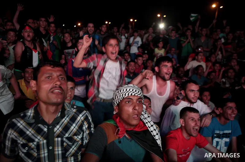 Palestinians celebrate in Gaza City on May 30, 2014, after Palestine qualified for their maiden Asian Cup appearance with a 1-0 win over injury-hit Philippines in the final of the AFC Challenge Cup in Maldives. Photo by...